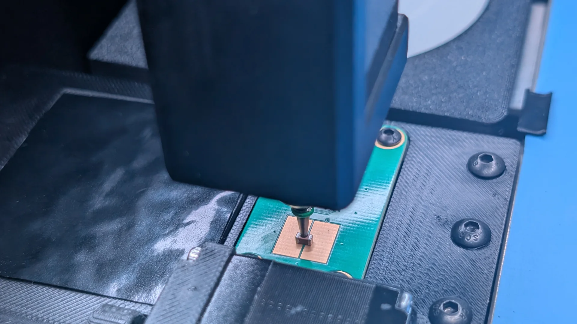 A nozzle holding a chip component onto the two impedance test pads